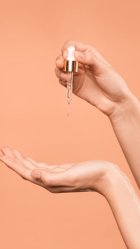 Hands demonstrating a skincare serum